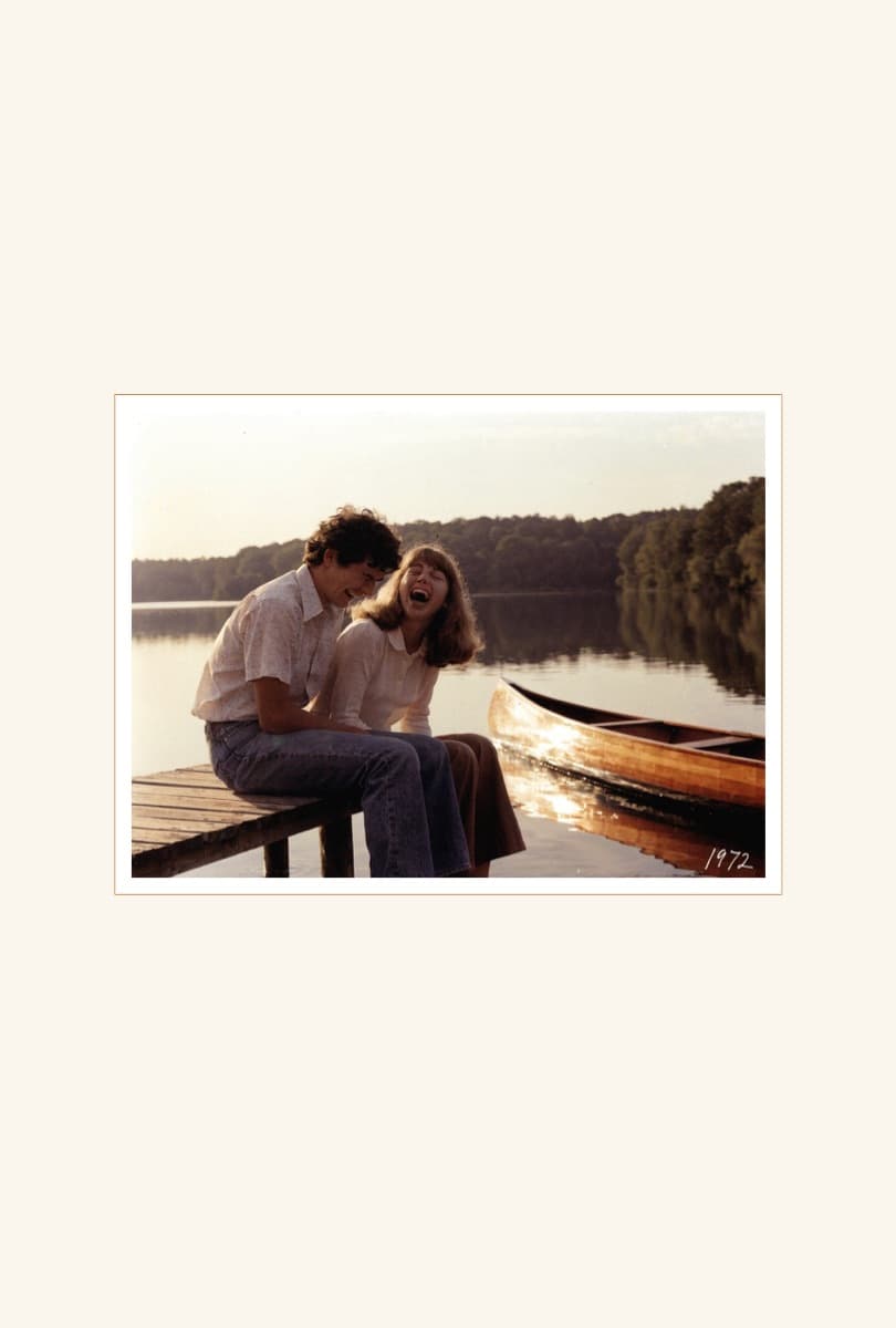 A full-page mounted photograph of a young couple laughing on a dock, dated 1972